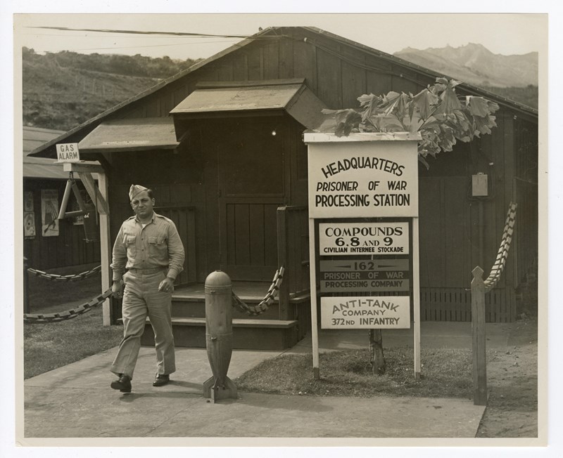 A historic photo of a soldier walking out of a barrack