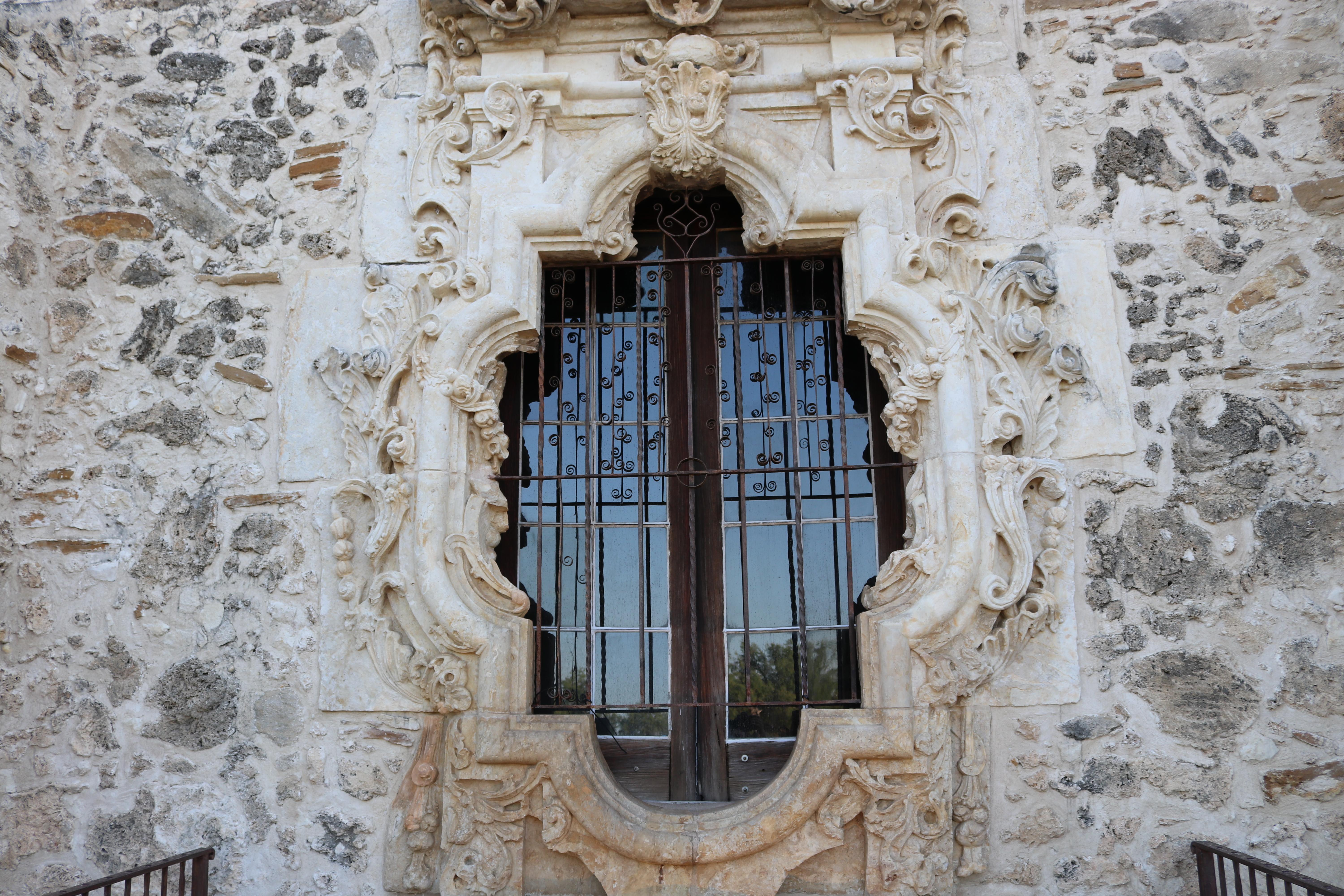 Rose window at mission San Jose, with linestone carvings surrounding a small glass window.