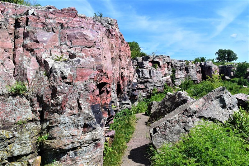 Sioux Quartzite Cliffs Pink wall of rock next to path and grass