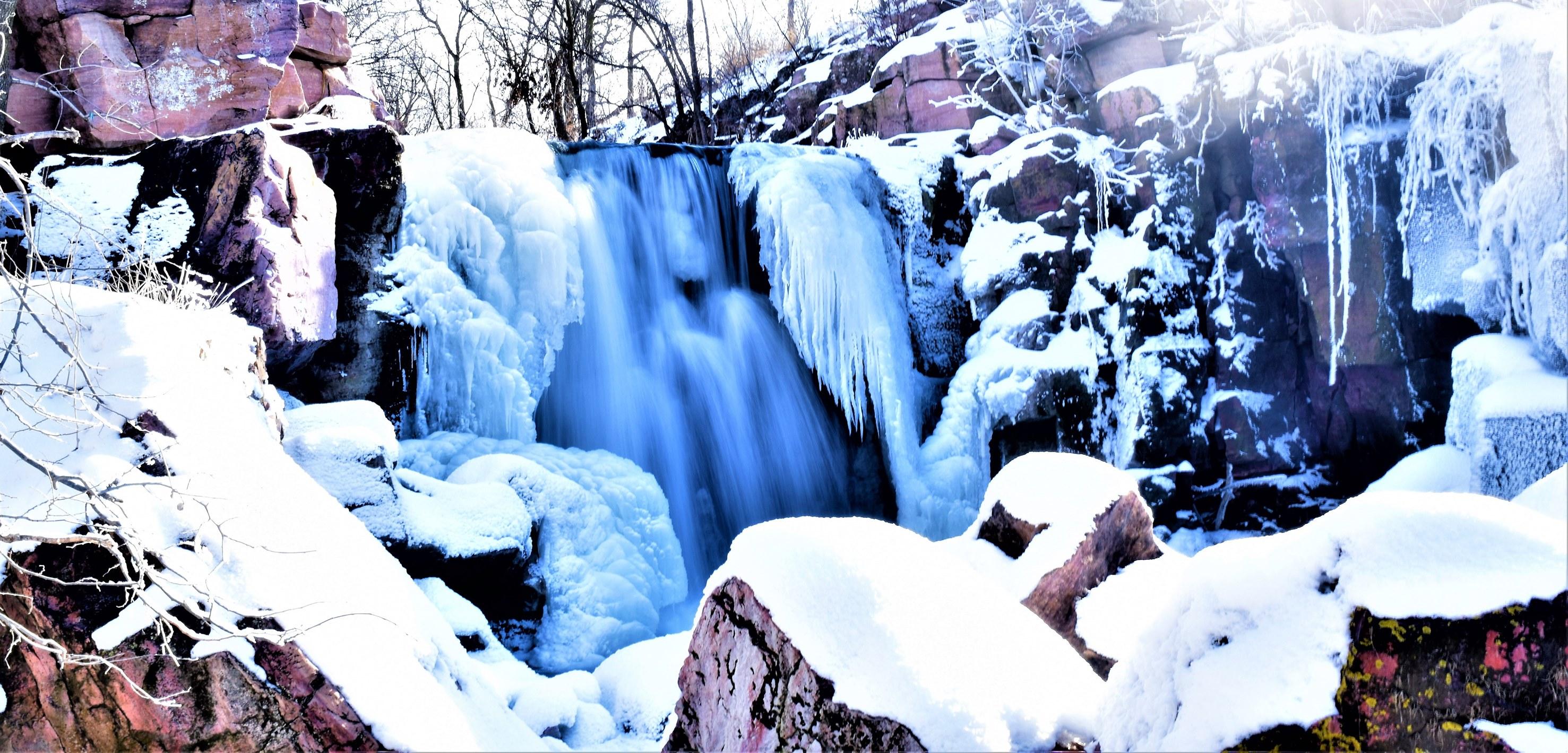 A waterfall partially surrounded by ice