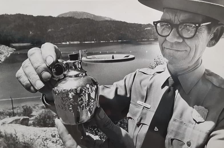 Park ranger with flat hat holding a small commemorative jug