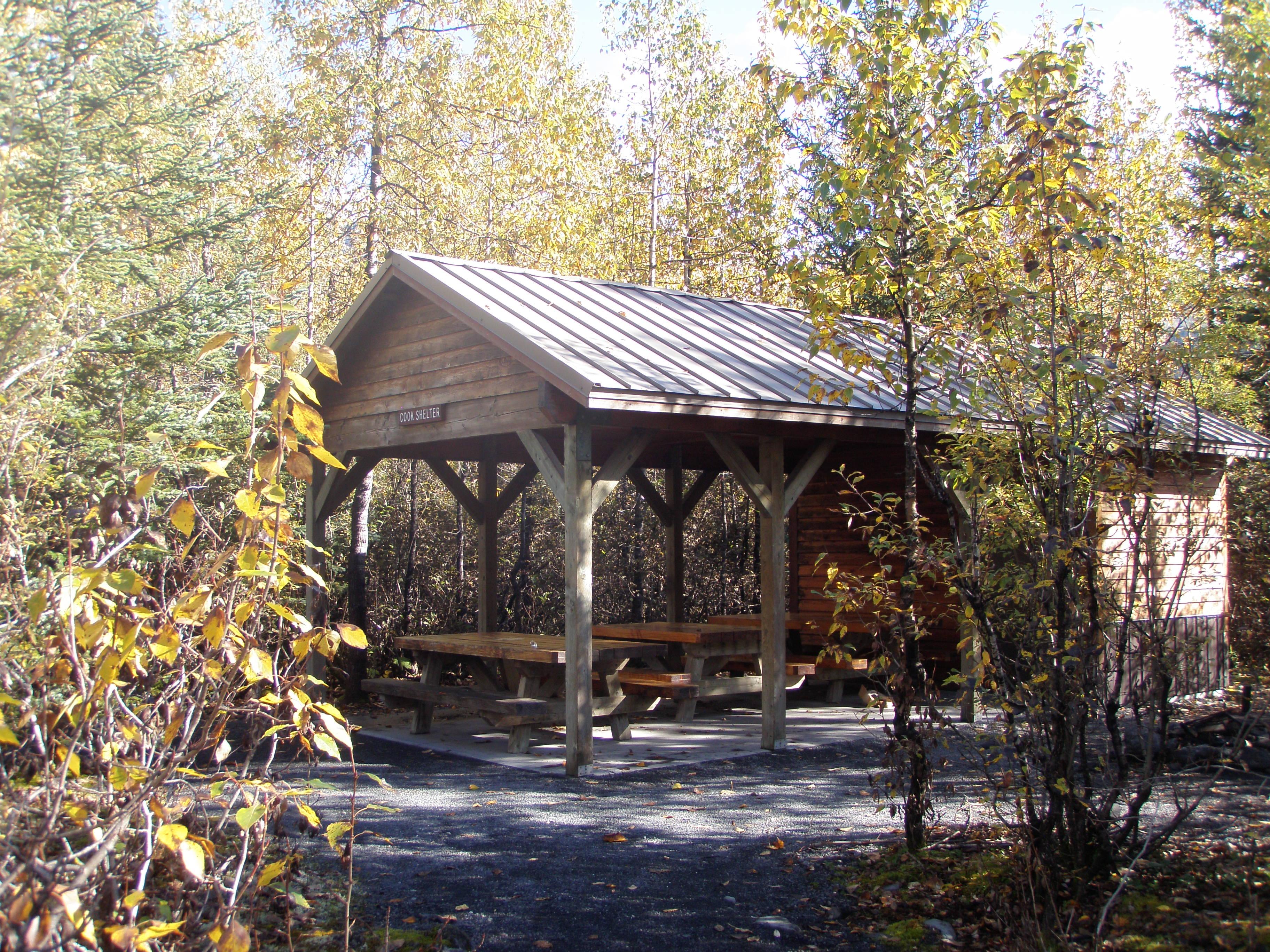 campground covered cook shelter with picnic tables.