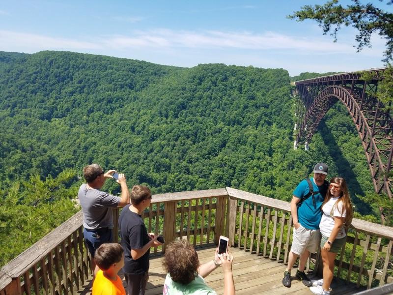 people posing for photos at an overlook