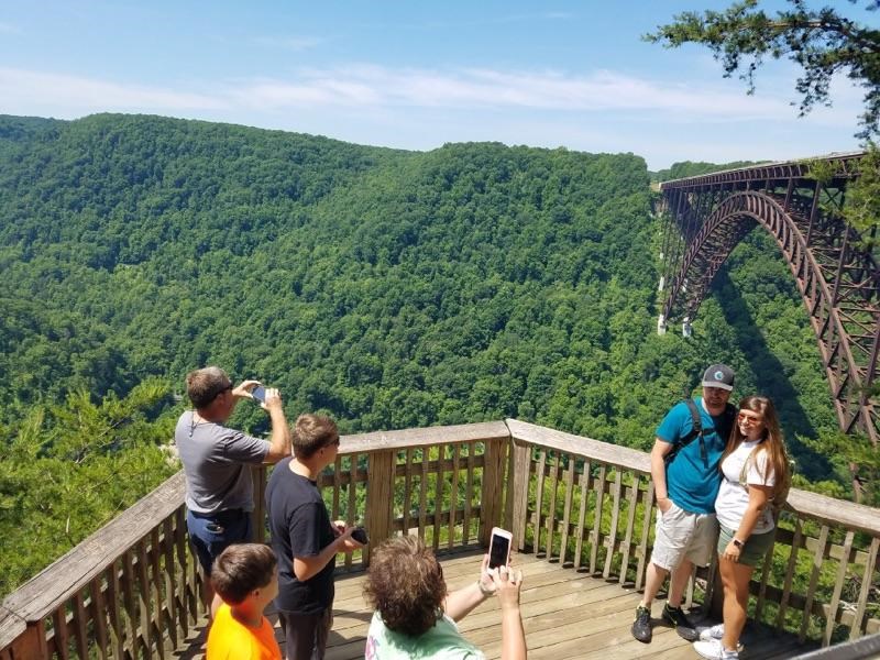 people posing for photos at an overlook