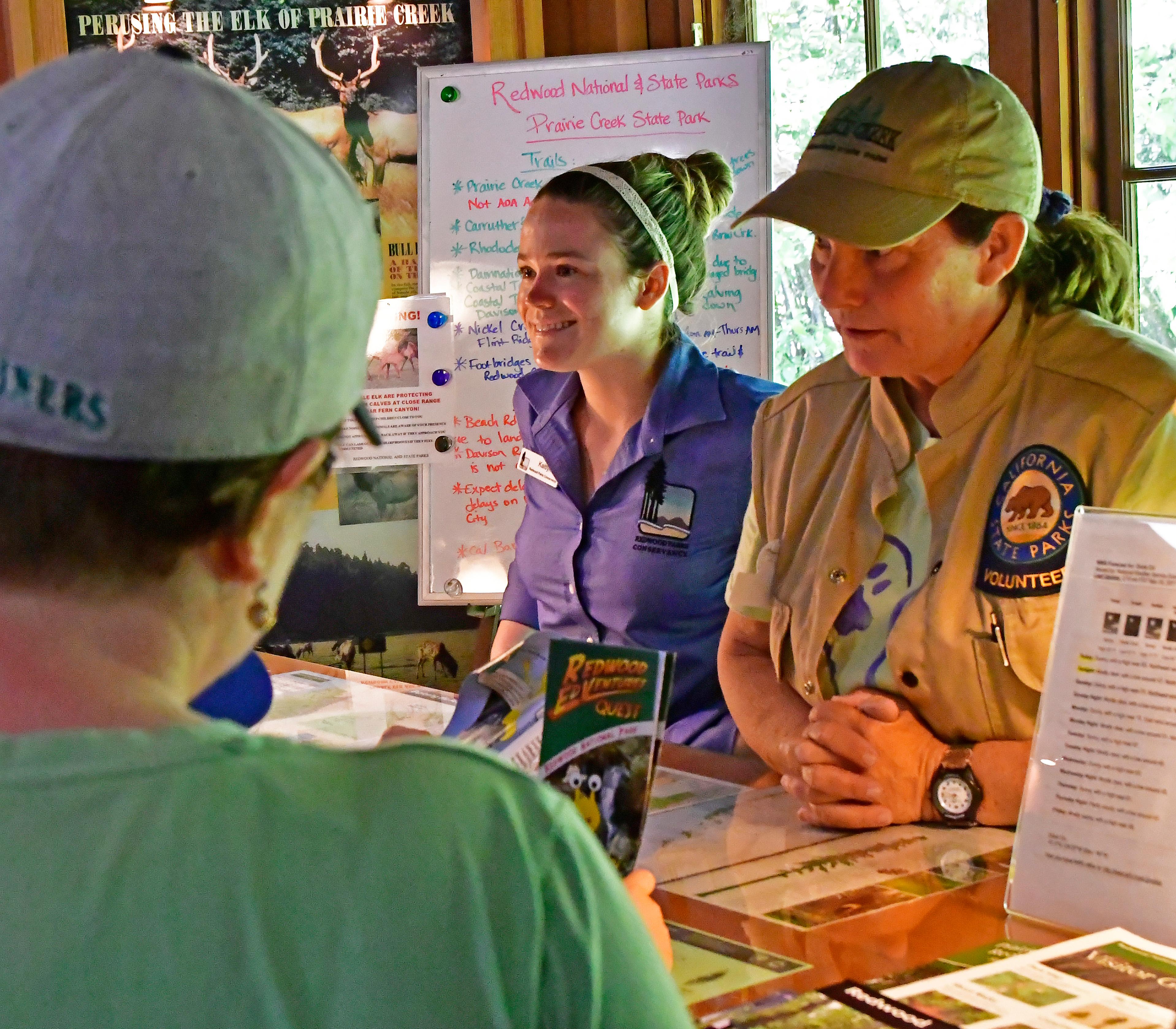 Three adults gather around an information desk.