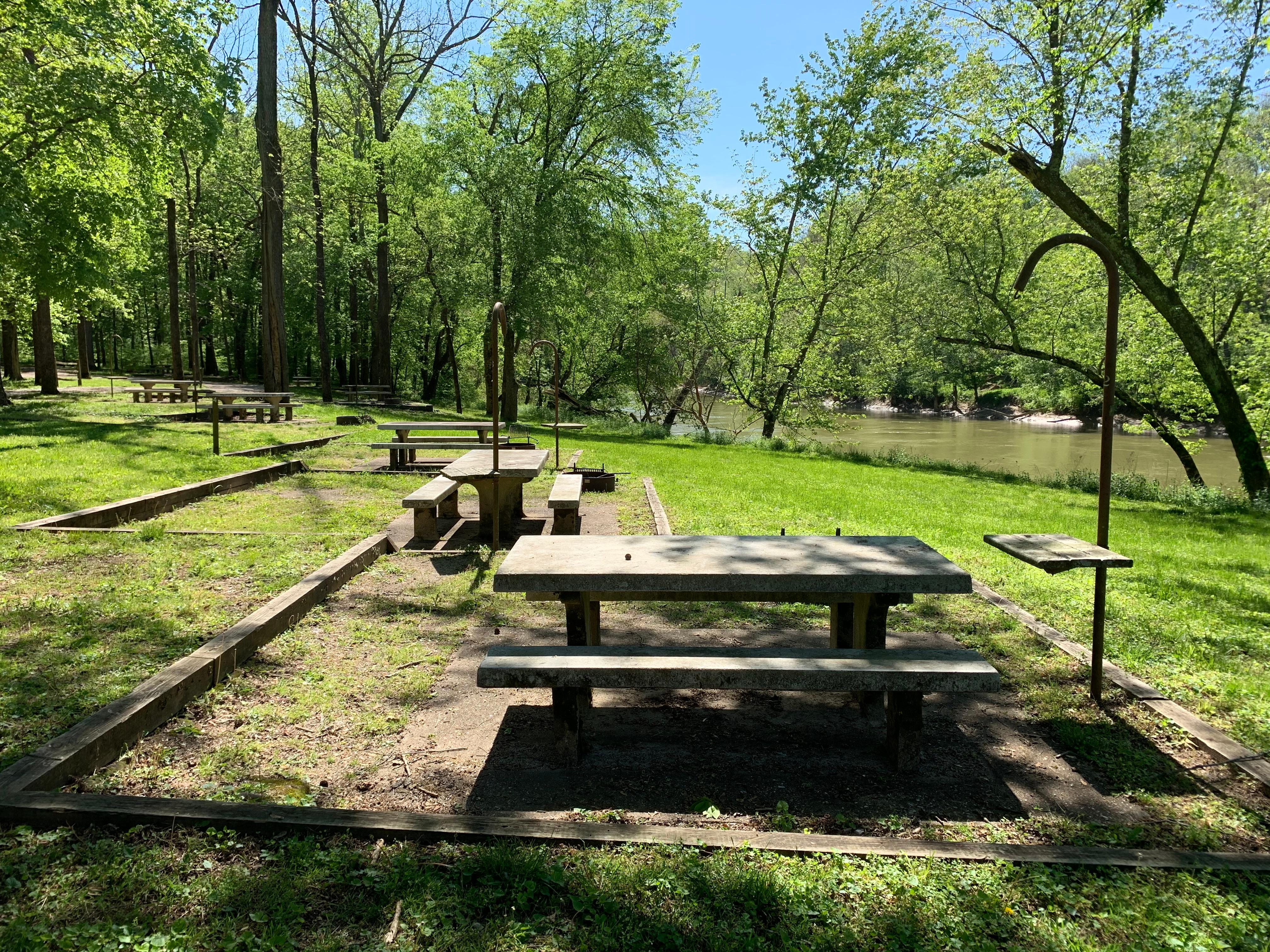 Campsites with picnic tables nearby the river.