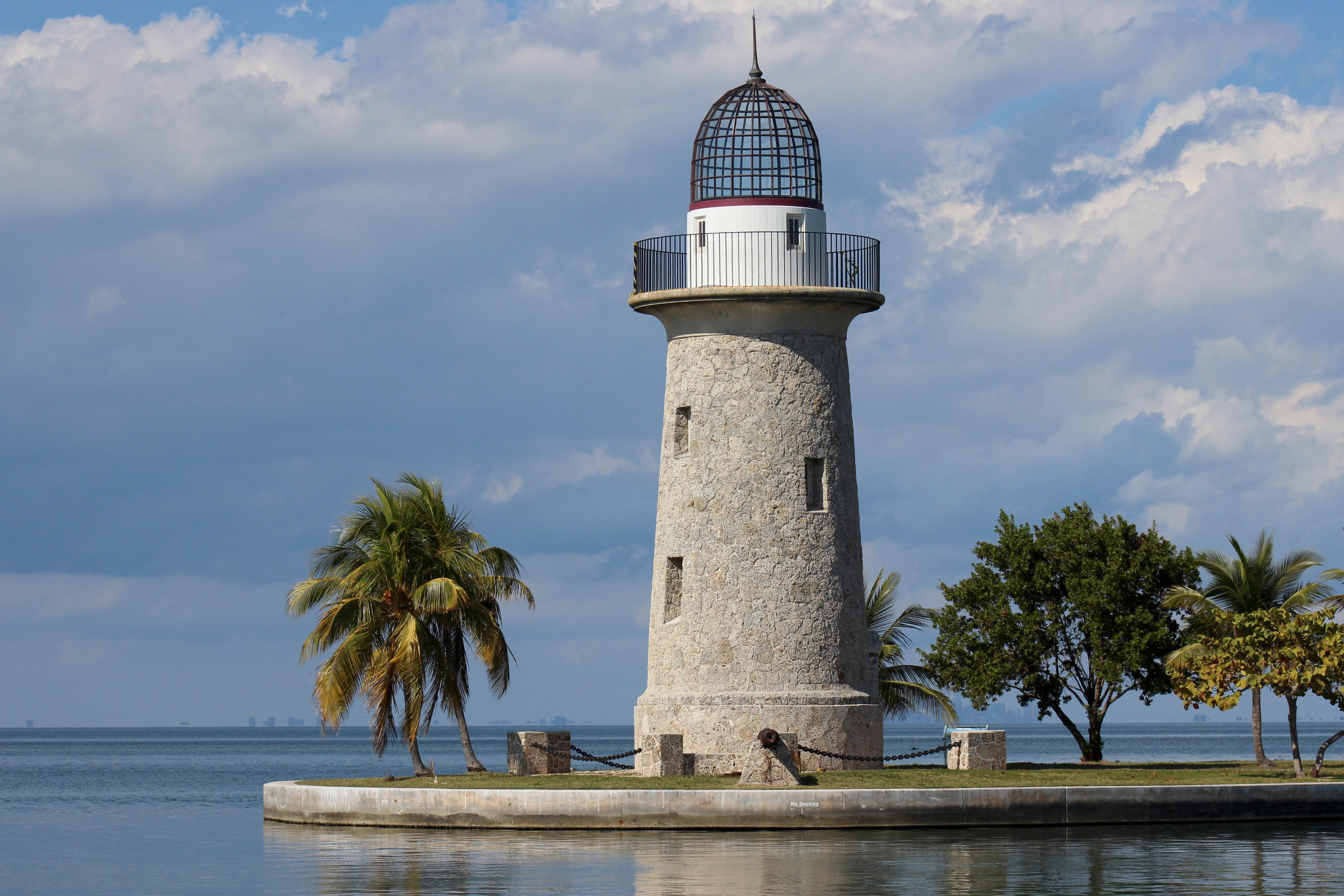 Stone lighthouse with glass dome stands at the mouth of the harbor