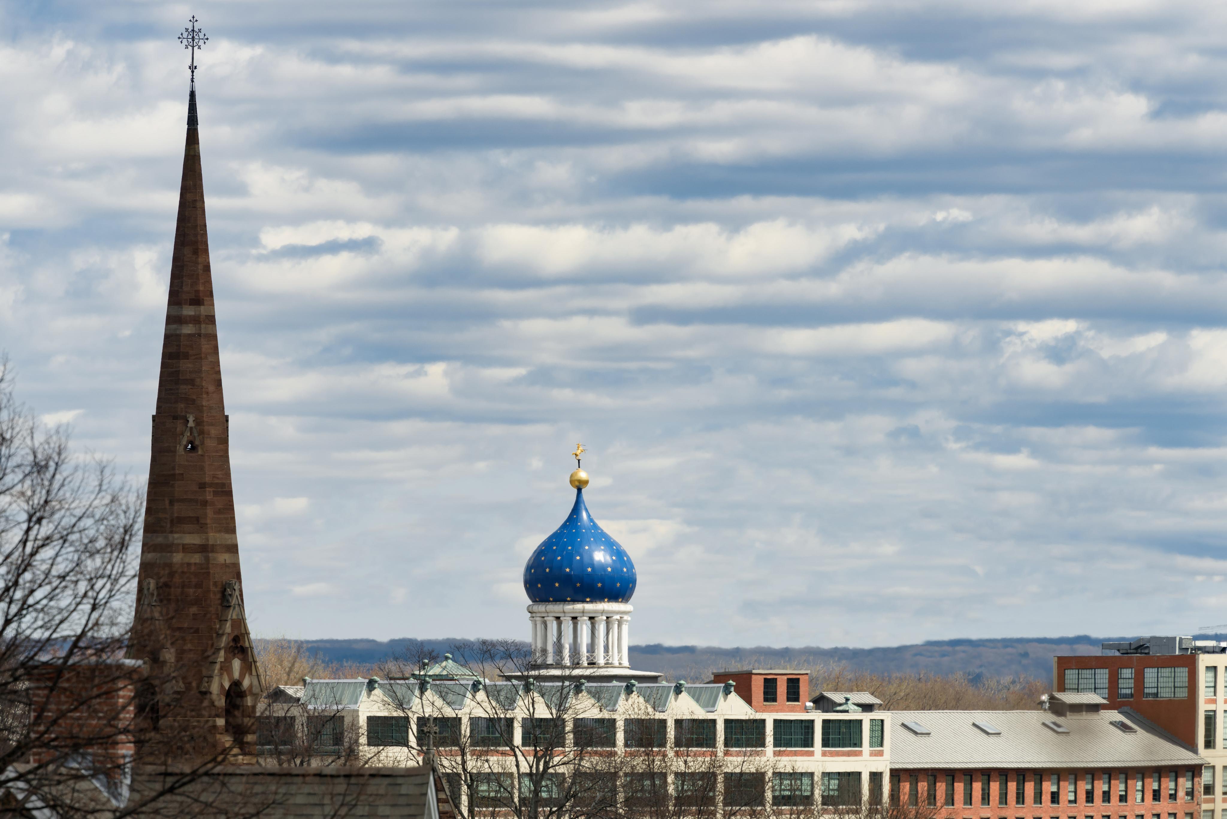 The Blue Onion Dome of the Armory and the spire of the Church against a cloudy blue sky.