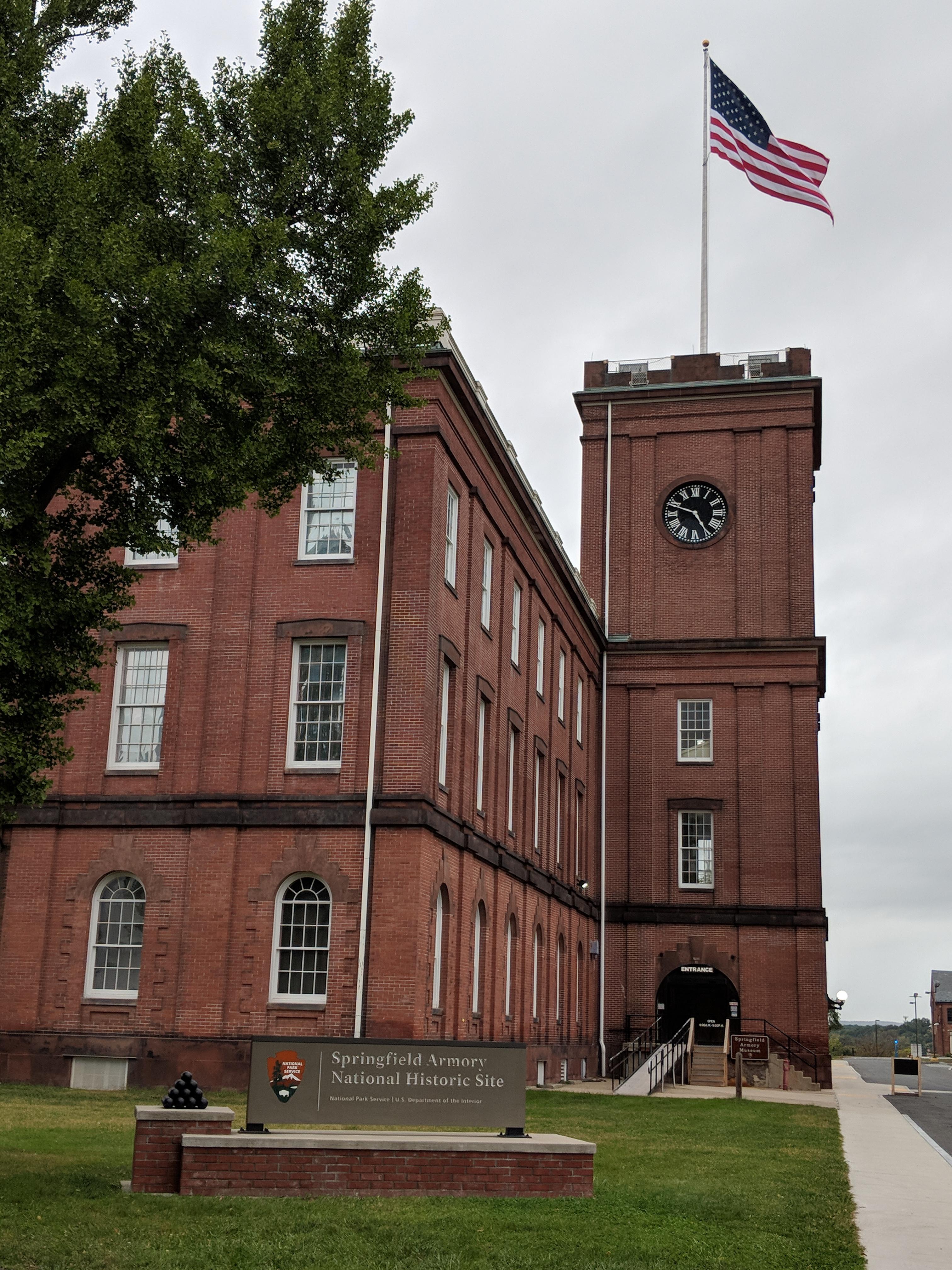 The tower of the Armory with the flag at full mast blowing in the wind on a cloudy day.