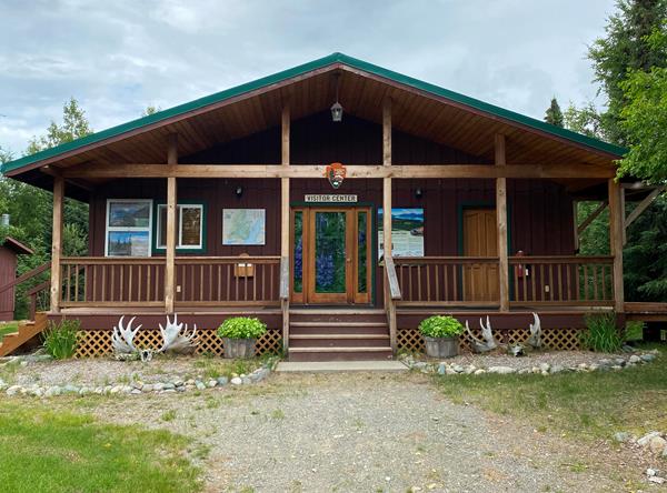 A wooden building with the NPS Arrowhead and outdoor exhibits