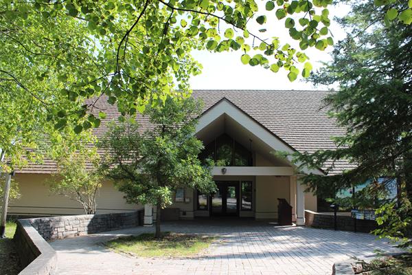 A visitor center building with a bulletin board located on the right.