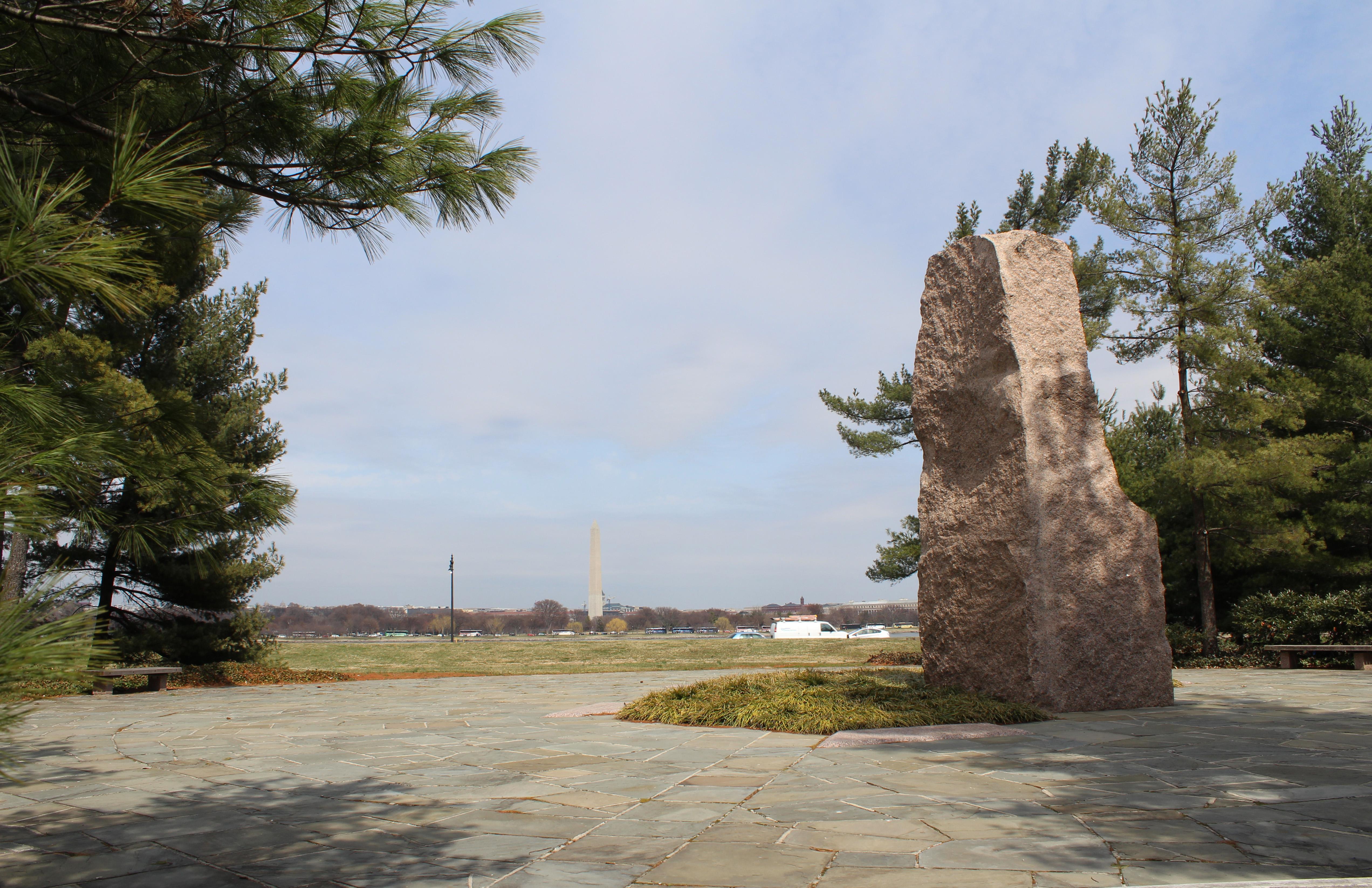 A stone memorial with the river and DC skyline in the distance.