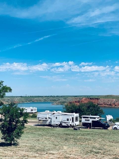 Sanford-Yake Campground with campers along the edge.  The sky is blue with white clouds.