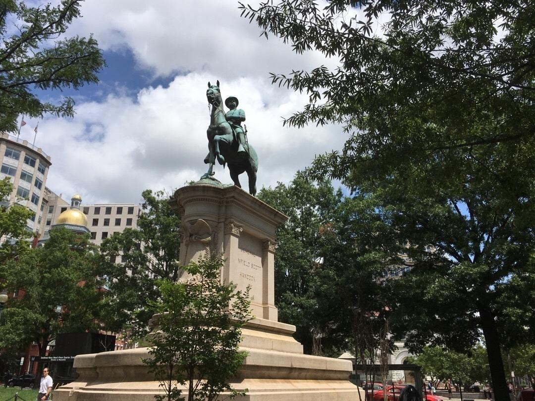 A bronze statue of a man on horse atop a stone plinth.