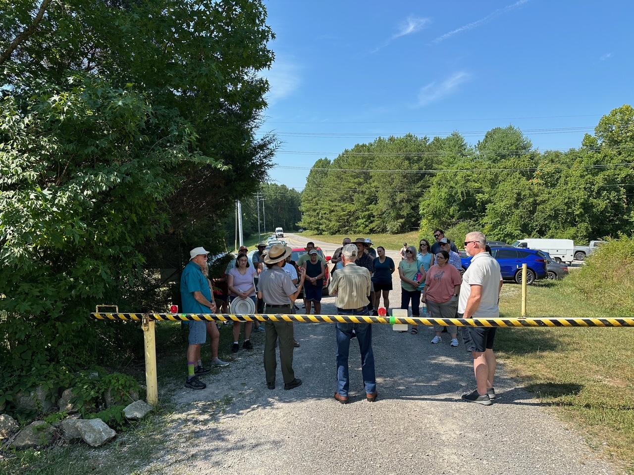 A ranger is surrounded by visitors at a security gate, awaiting a ranger-led walk.