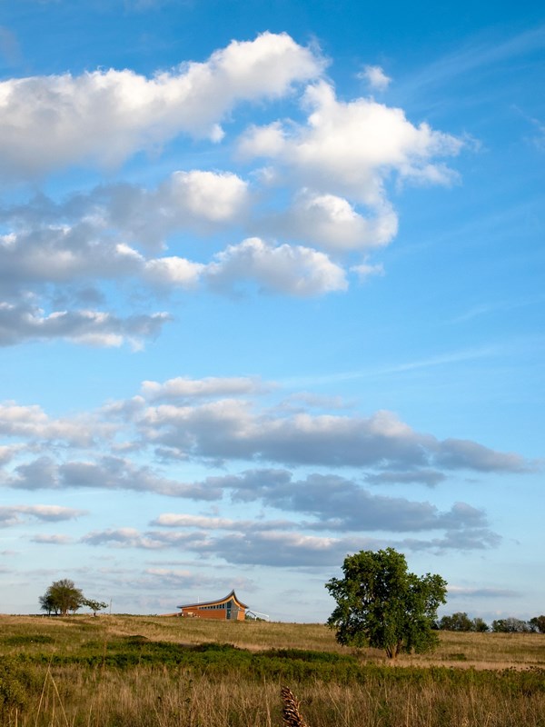 The tallgrass prairie spans to the Heritage Center on the horizon.