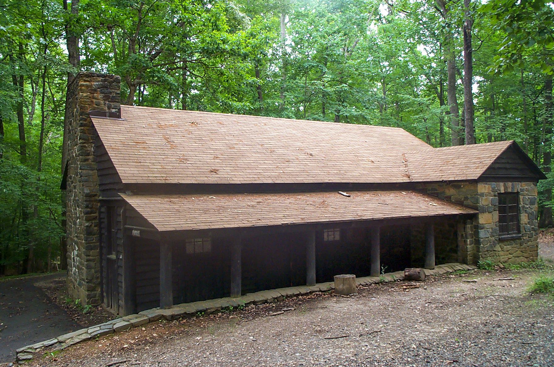 A stone and wood cabin sits among the woods