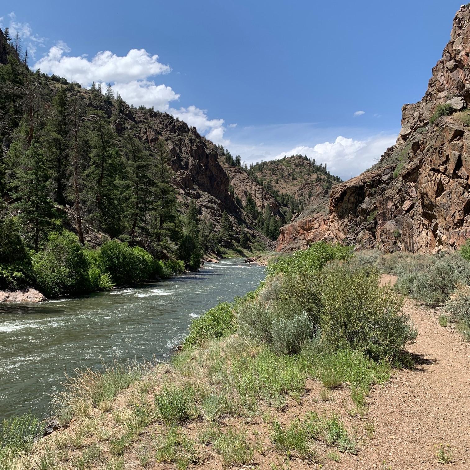A path along a canyon with a river on the left side