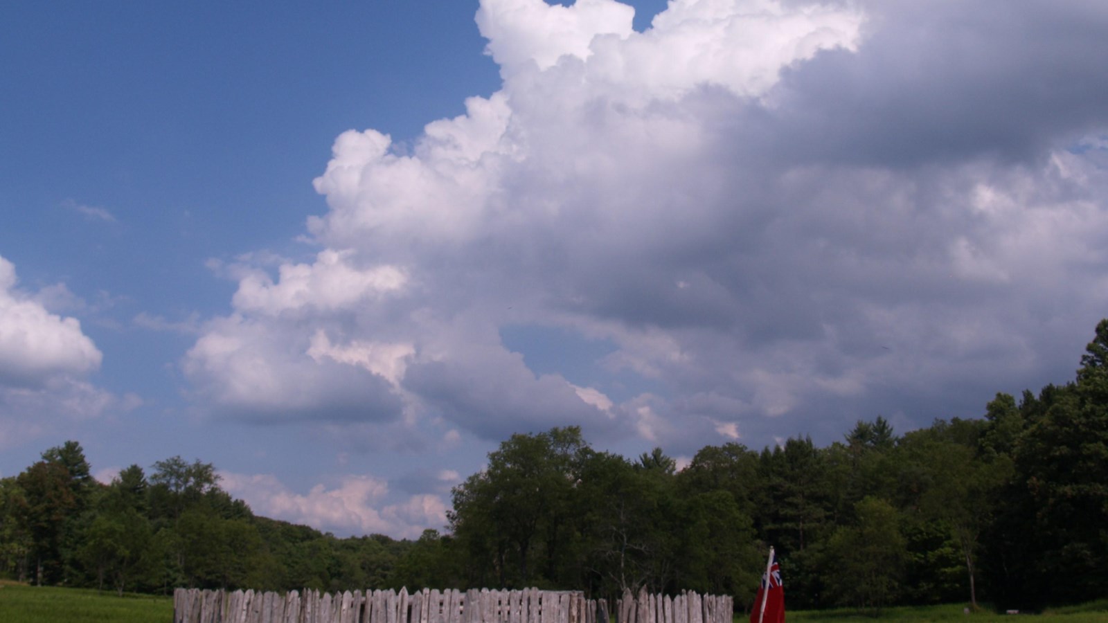 Fort Necessity grounds and reconstructed fort under a cloudy sky.
