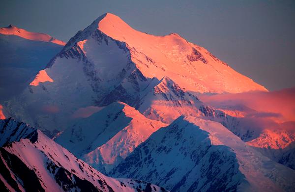 light turns a snowy mountain shades of pink and purple