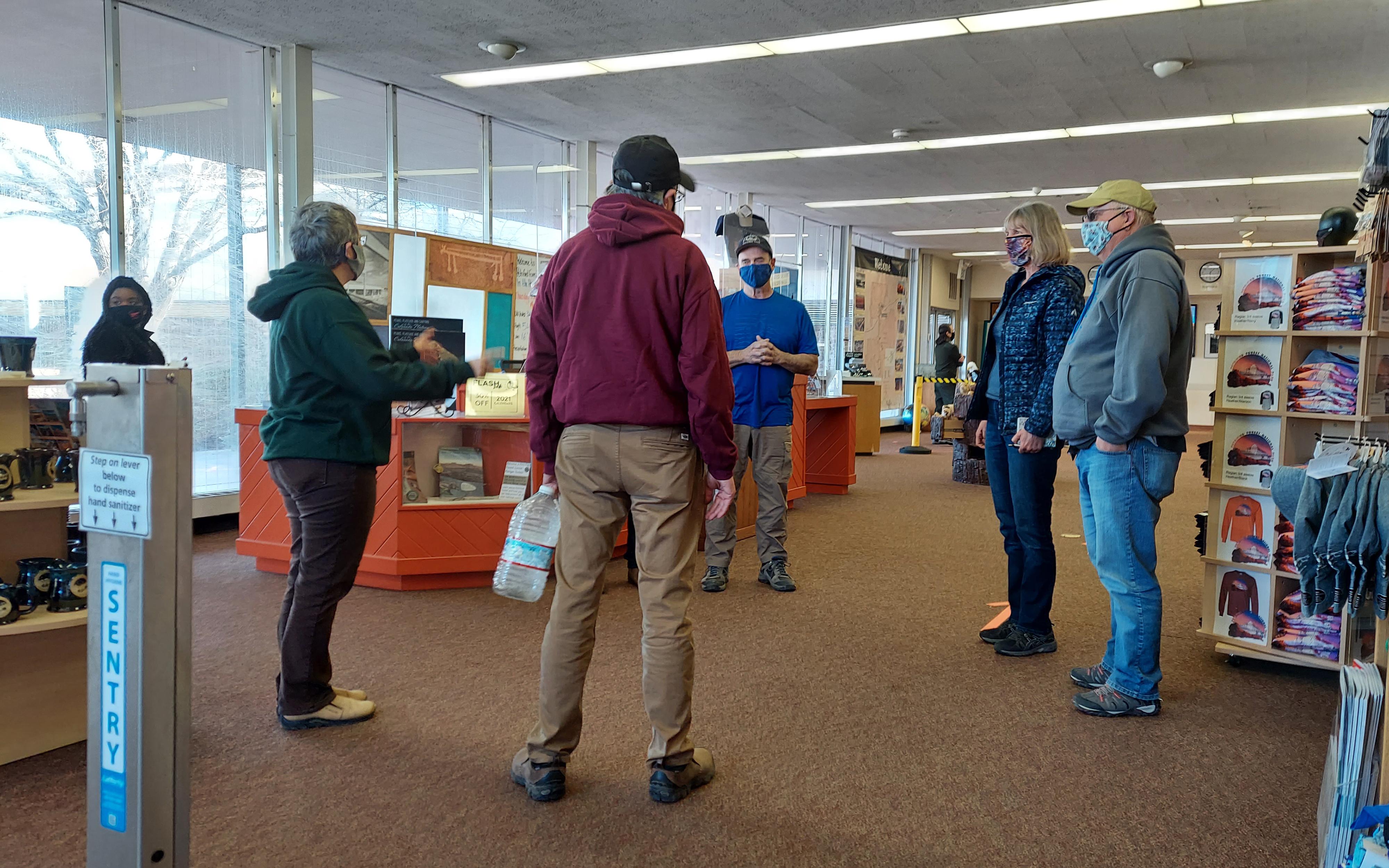 People inside visitor center wearing masks, displays in background