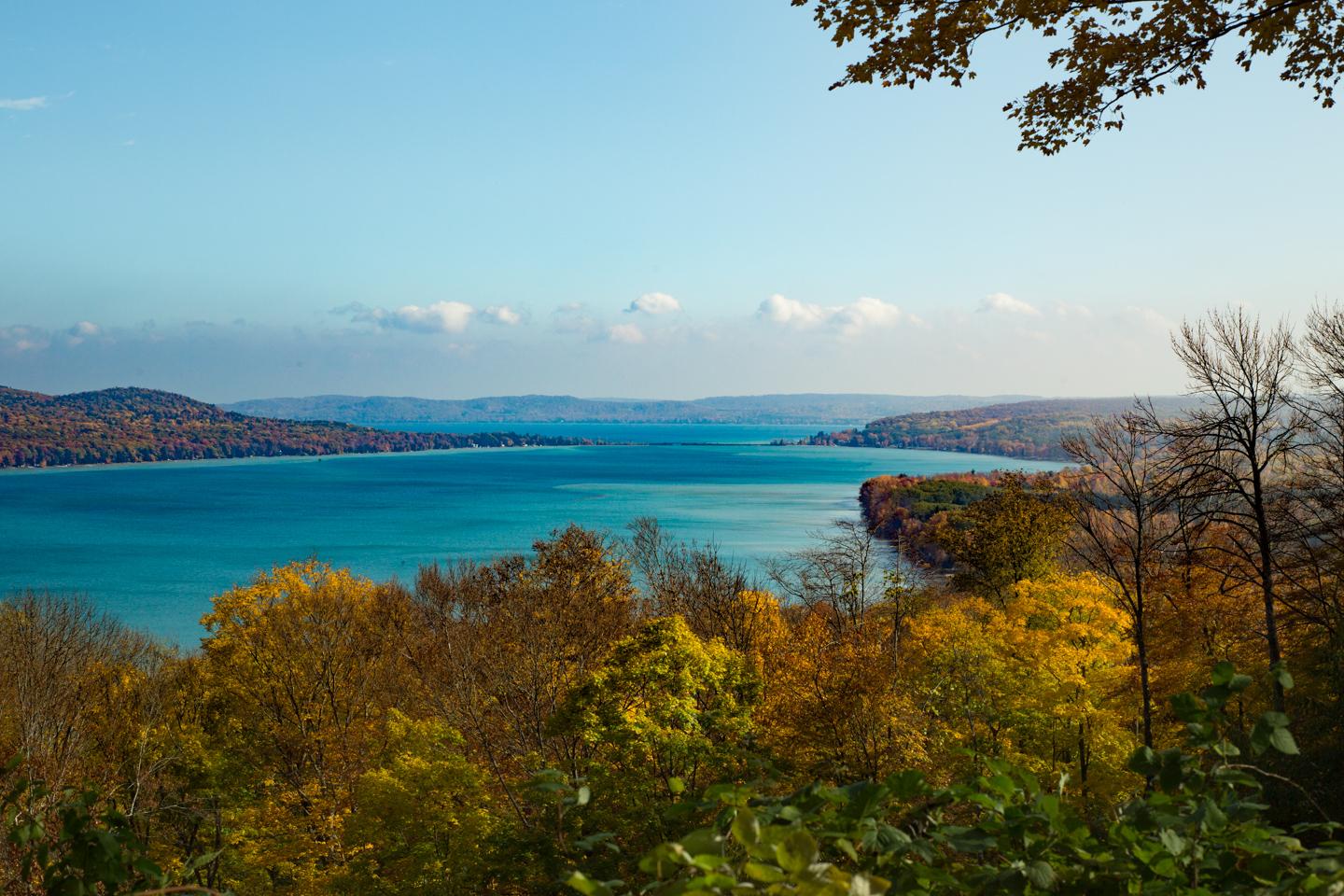An overlook of two blue lakes surrounded by trees with fall leaves