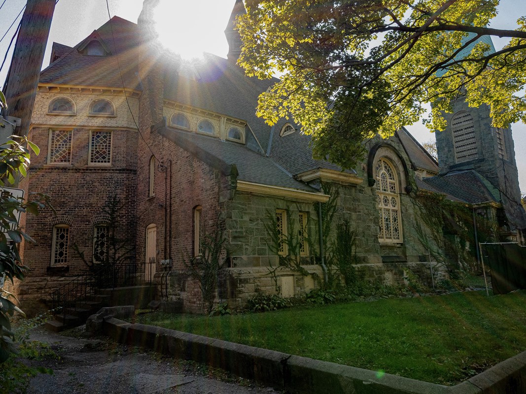 An image of the Greenstone Church with the sun peeking over the top of it