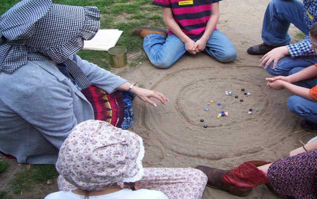 Students engage in a game of marbles.