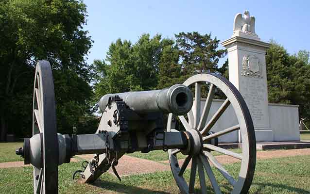 A Civil War cannon in front of a monument. A Civil War cannon in front of a monument.