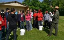 Park ranger and school kids standing on grass field in front of building