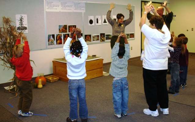 A Park Ranger leading children in a dance