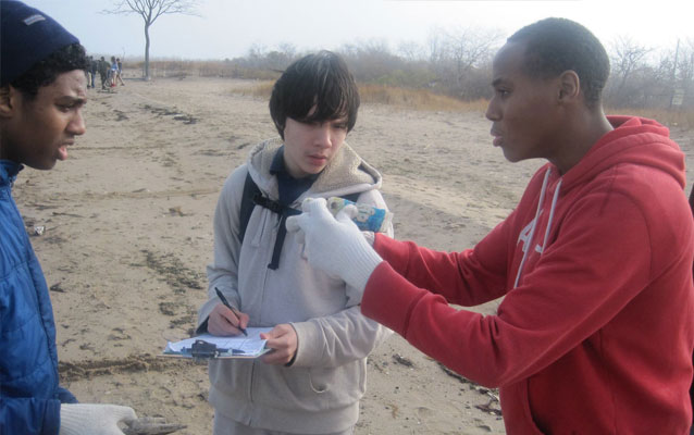 Students picking up trash on a beach at Gateway Students picking up trash on a beach at Gateway