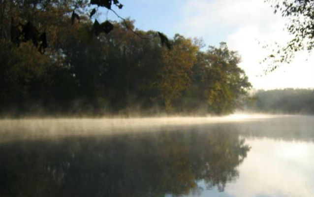 Mist rises from the mirror-smooth Current River, Ozark National Park