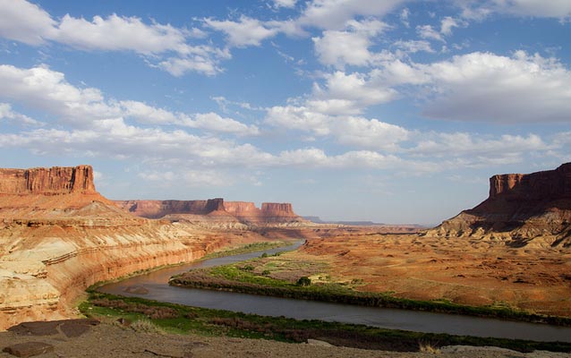a river flows between tall red-rock buttes