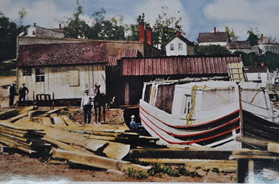 A colorized photo of a canal boat, lumber and workers in a boatyard along the Ohio and Erie Canal A colorized photo of a canal boat, lumber and workers in a boatyard along the Ohio and Erie Canal