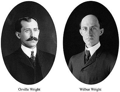 black and white portrait photos of two men in suits the left has a mustache the right is clean shaven.