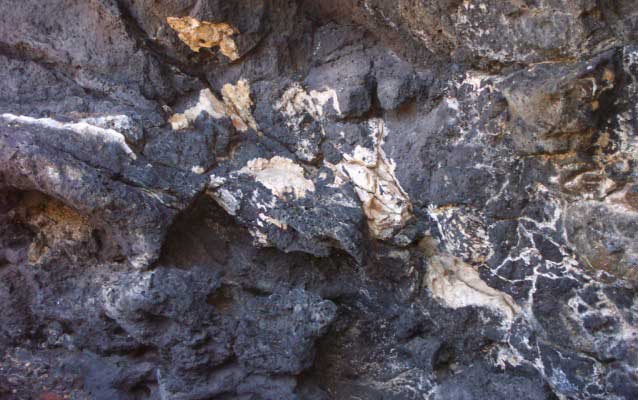 Photograph of dark rock surrounding light rock.