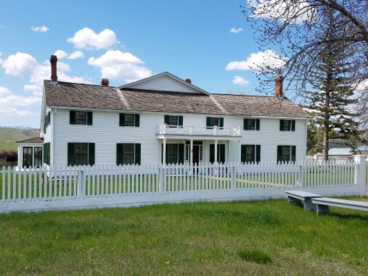 White two story house with green shutters and a white picket fence around the lawn White two story house with green shutters and a white picket fence around the lawn