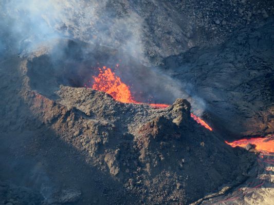 a small erupting volcano with lava pouring out of it a small erupting volcano with lava pouring out of it