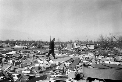 President Lyndon B. Johnson visits flood & tornado damaged areas of the Midwest. He's walking among debris
