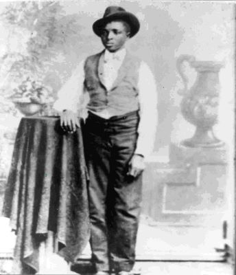 A young teenage boy standing with his hand on a table, looking to the right A young teenage boy standing with his hand on a table, looking to the right