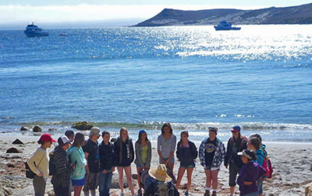 Kids learning on island white sand beach.