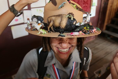 A smiling Ranger whose hat is covered in toy animals. A smiling Ranger whose hat is covered in toy animals.