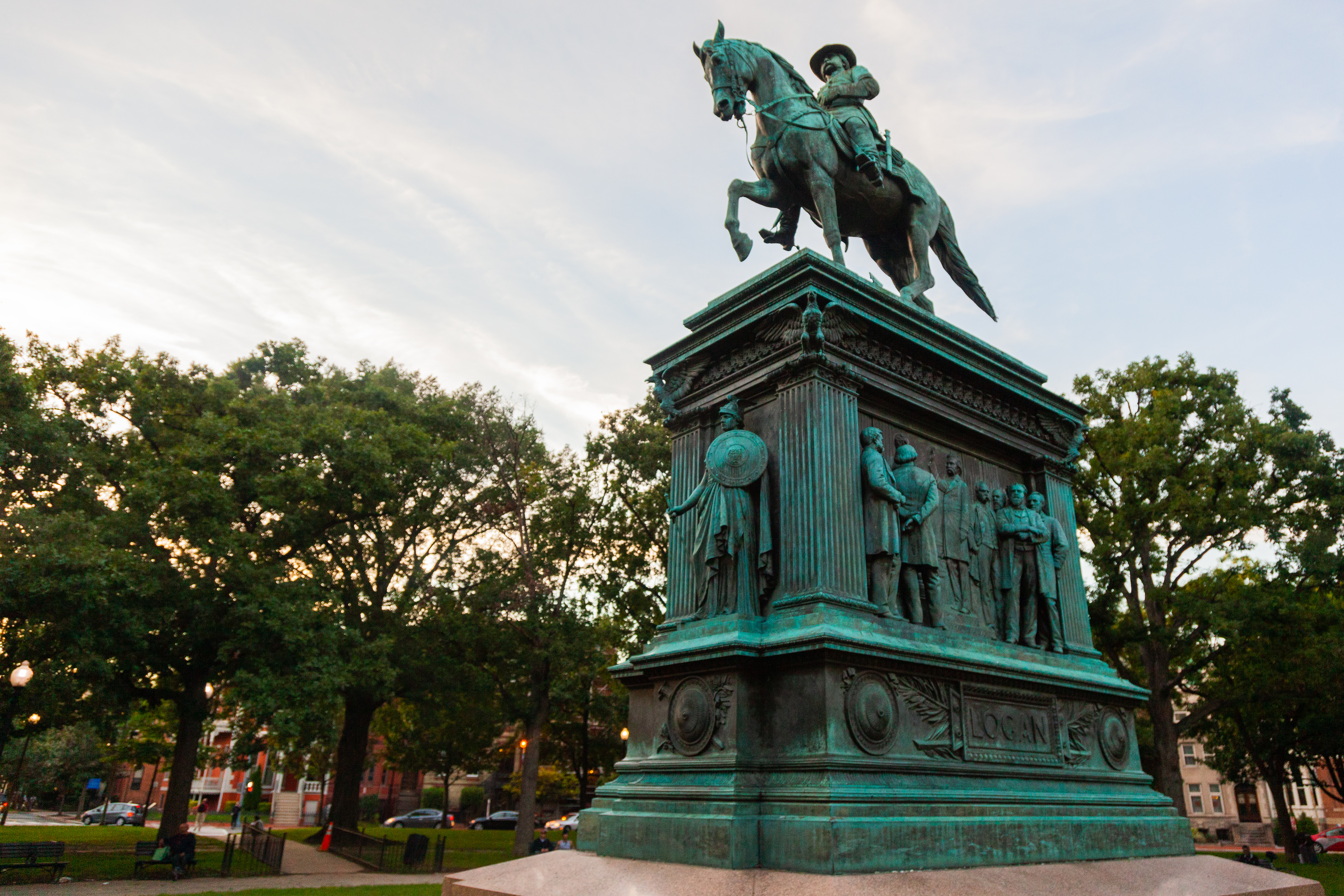 Bronze equestrian statue on a large bronze plinth that says "Logan" with images of men in suits.
