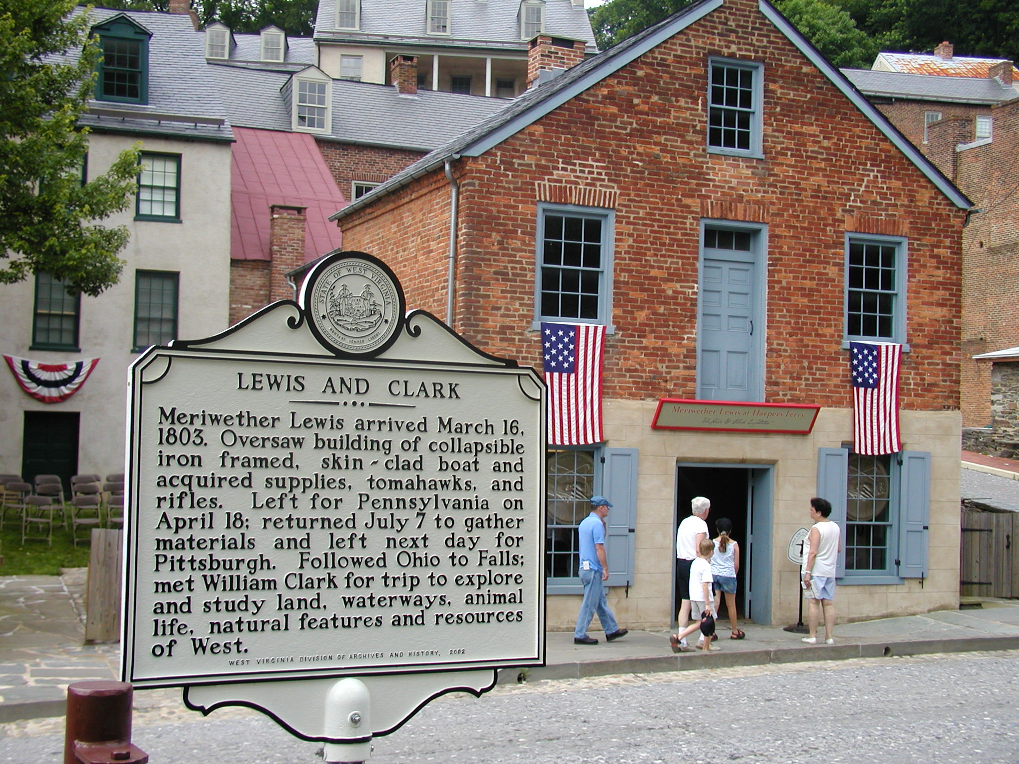 Two-story brick building labeled Meriwether Lewis at Harpers Ferry. Historical marker in foreground