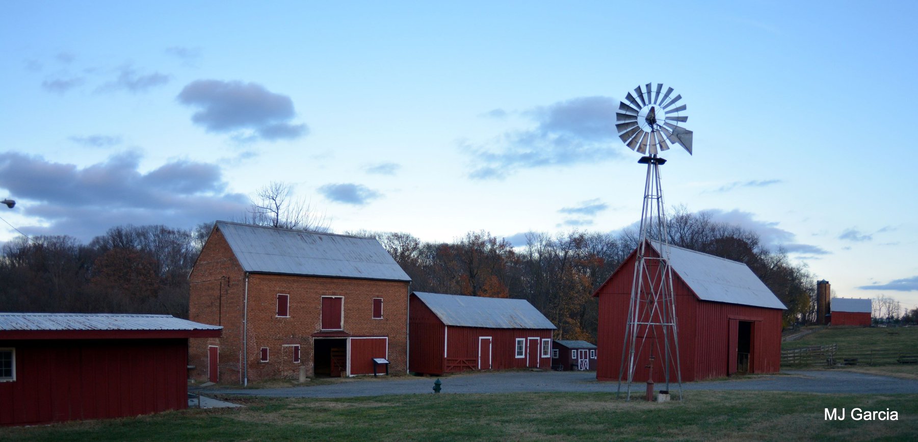 3 red barns, a brick stable, and a metal windmill