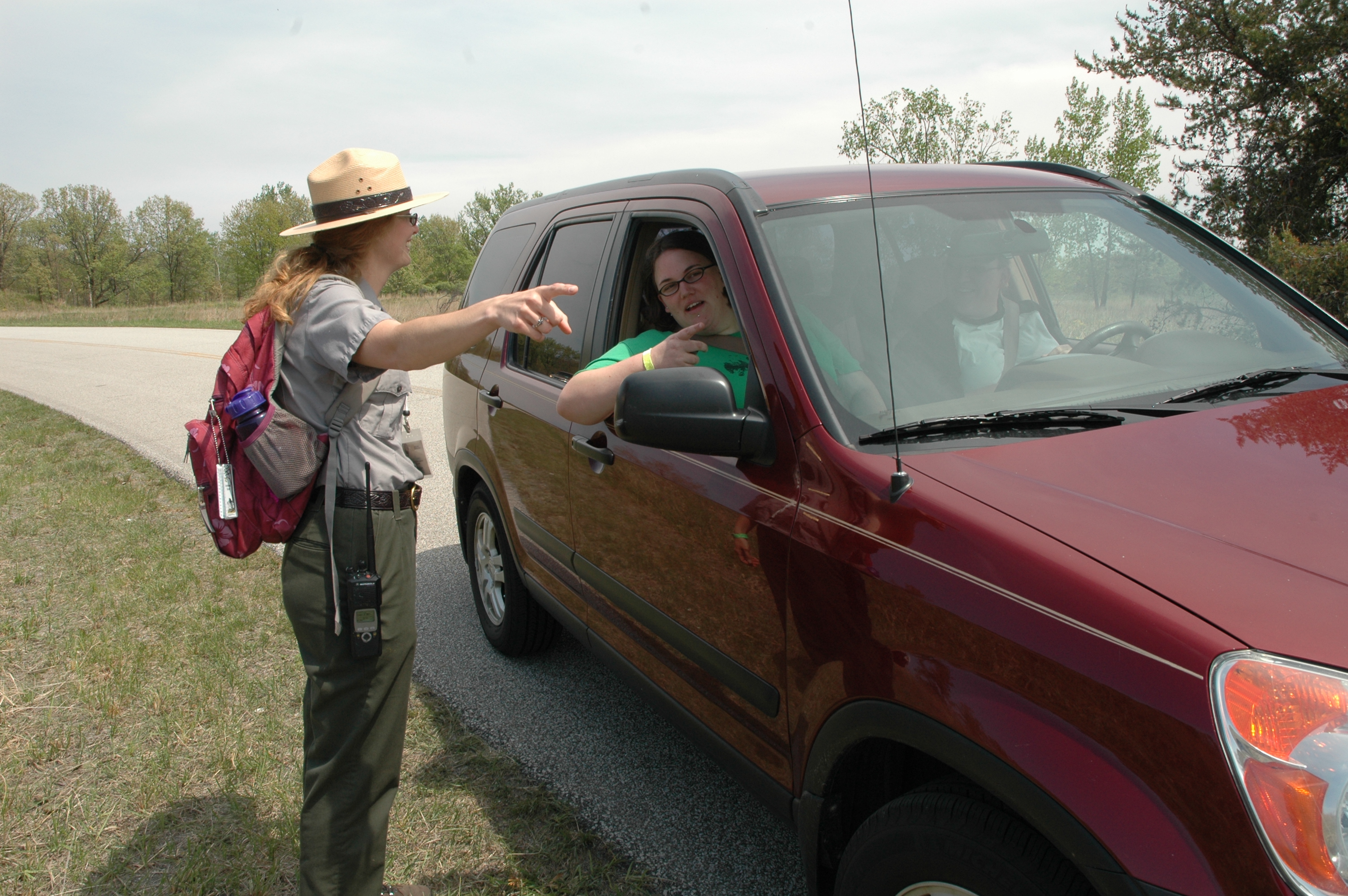 A Ranger points directions to someone in their vehicle.