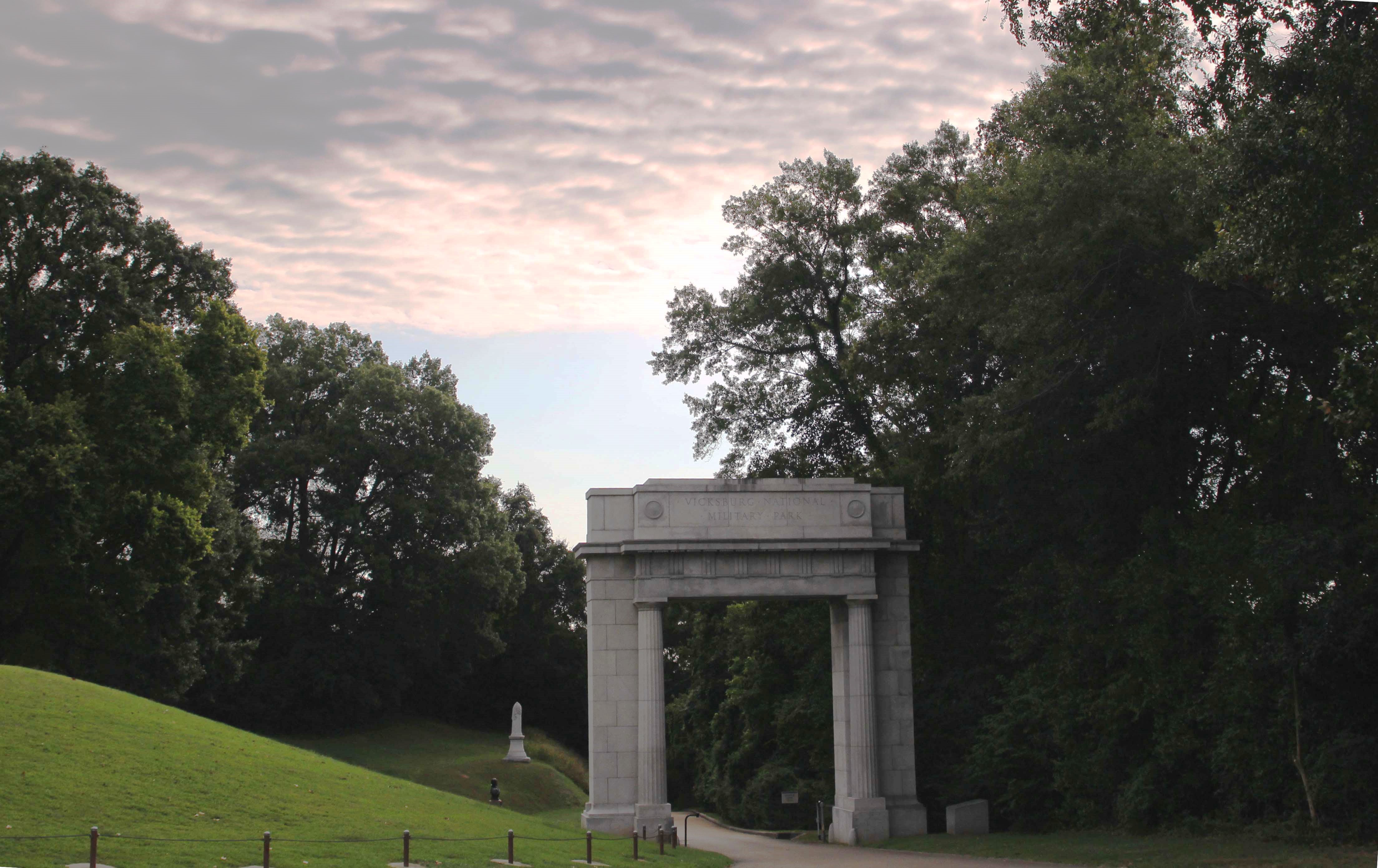 Pink, wavy clouds float over the Memorial Arch at the beginning of the park tour road.