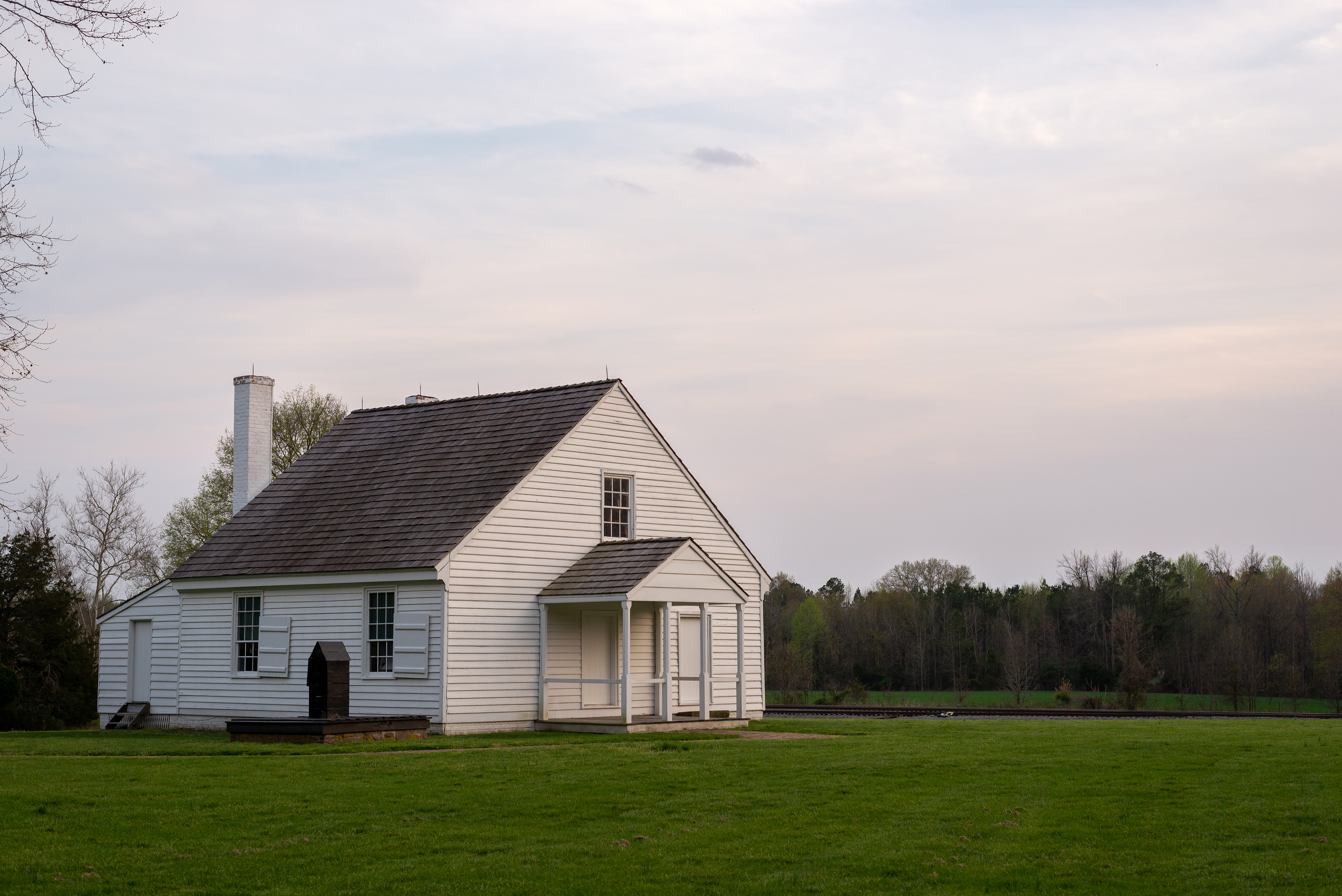 A small white building in a field of grass.