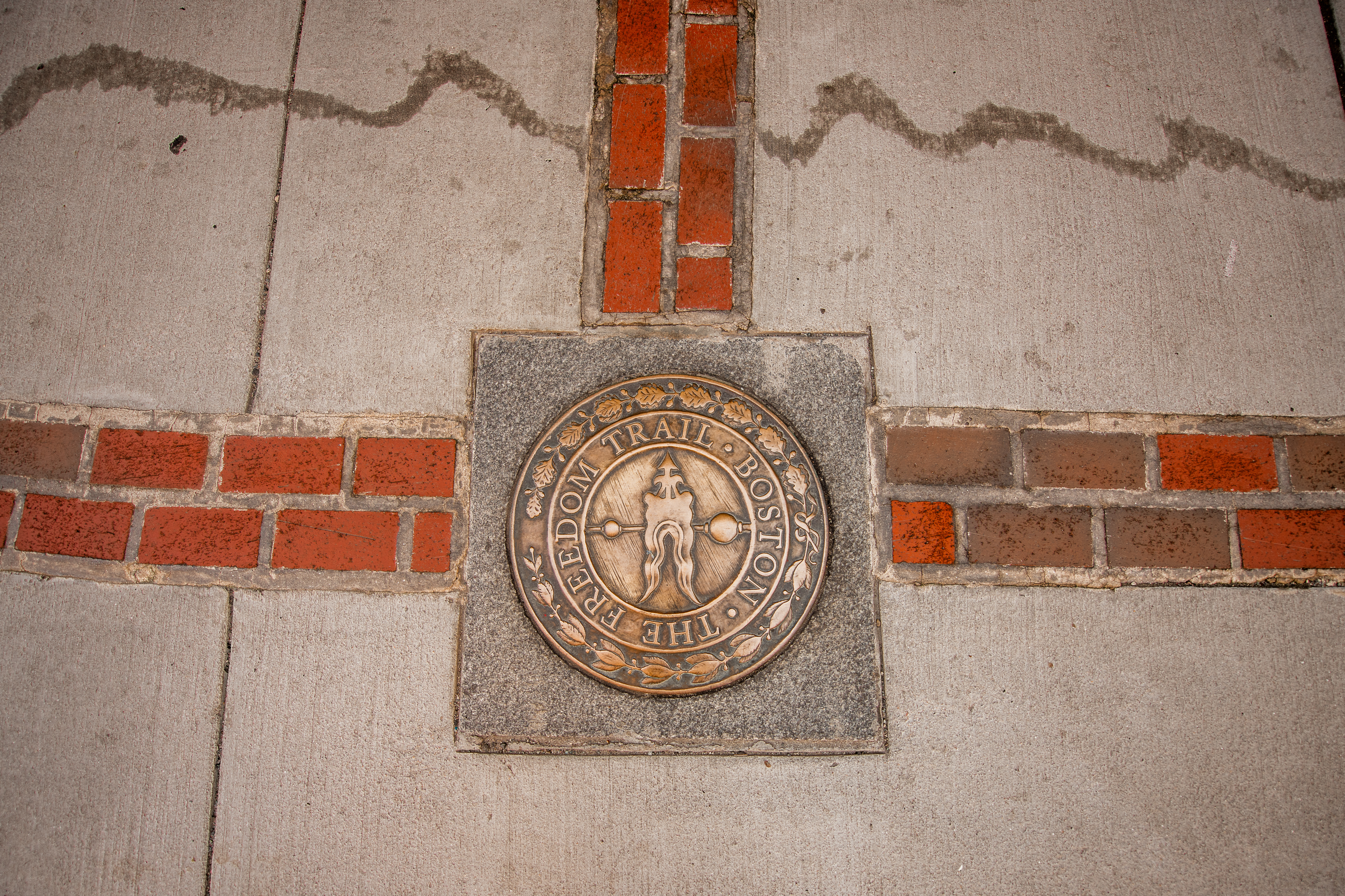 Freedom Trail medallion with brick lines extending in three directions